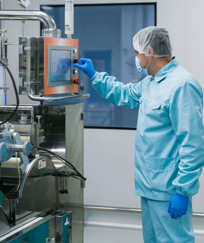 cleanroom operator using automated industrial equipment in manufacturing environment
